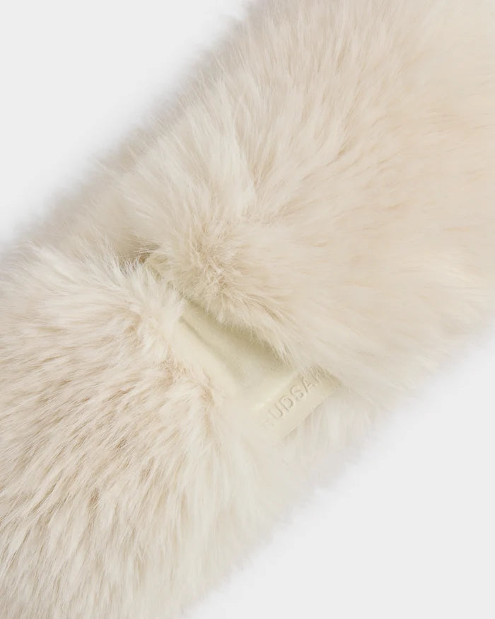 A close-up of the ARLETTE - 8425544 Vanilla women’s faux fur headband by Rudsak, in fluffy cream with cozy-chic style and a beige embossed tag—a perfect winter accessory.