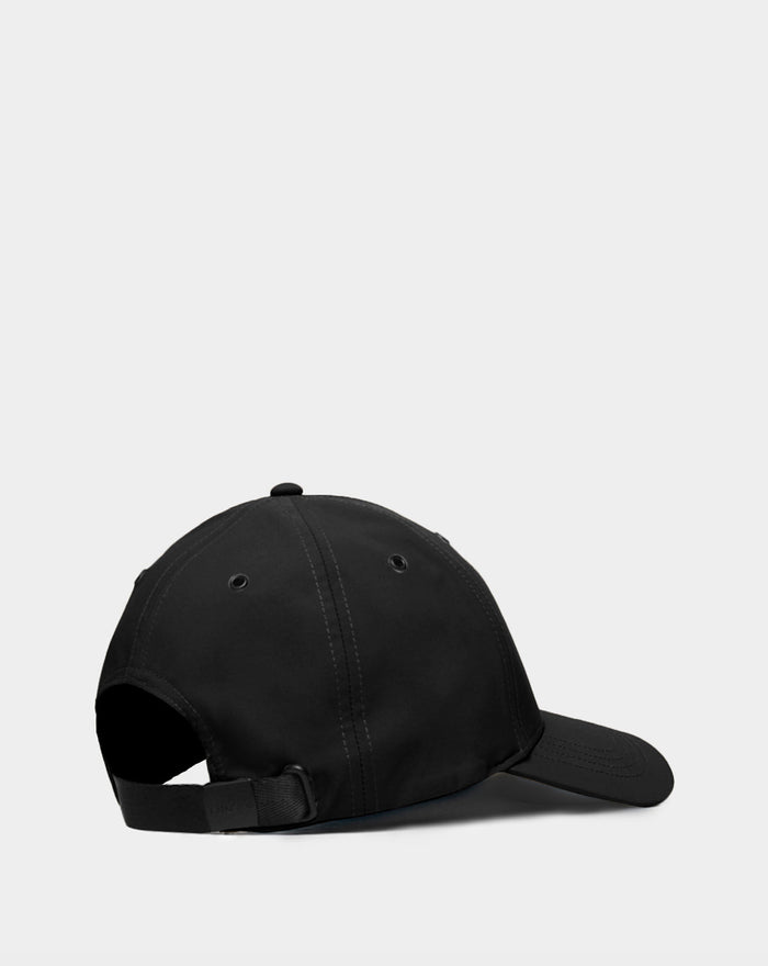 The Rudsak ARSENE - 9422504 Black unisex baseball cap is shown from the back, highlighting its adjustable strap with metal clasp and stitched crown eyelets, set against a plain light background.