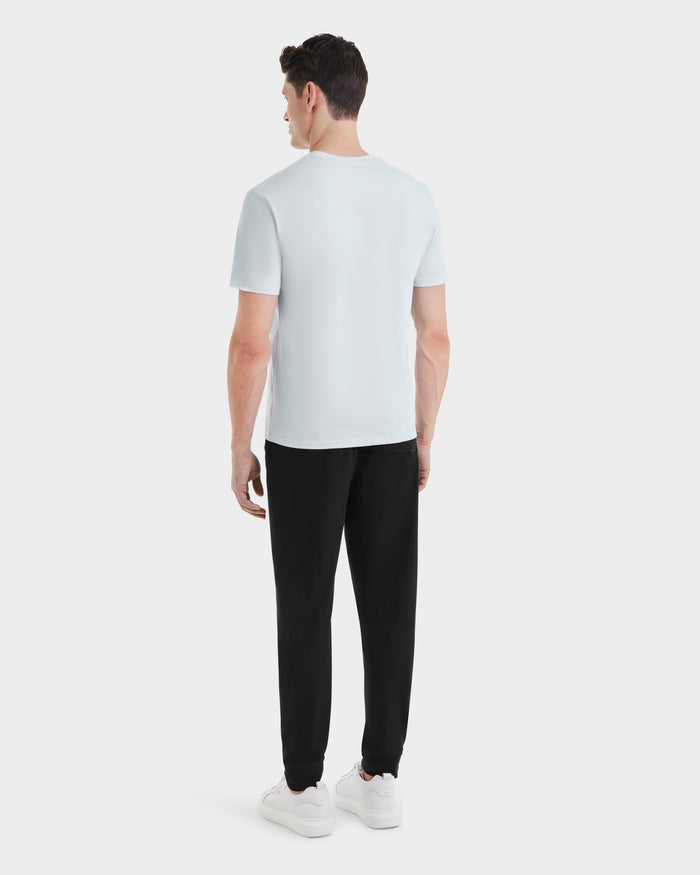 A man wearing the Rudsak ASHER - M525000 Sky Blue mens cotton t-shirt featuring a minimalist chest logo.