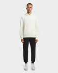 A man stands facing forward wearing the Rudsak BARRY - 9524011 Iceland M unisex oversized hoodie, paired with black pants and white sneakers, against a plain light gray background.
