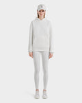A person stands facing forward in the Rudsak BARRY - 9524011 Iceland W hoodie, paired with leggings, sneakers, and a baseball cap—an effortlessly cool look against a plain white background.