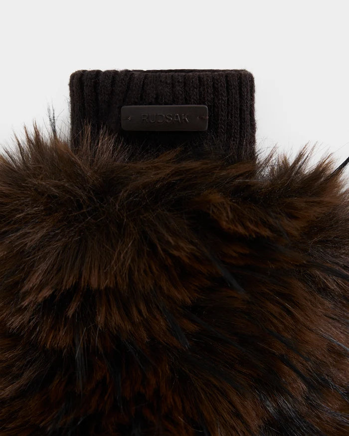 A close-up of the BELLA - 8425006 Mix Espresso mitten by Rudsak highlights its luxurious brown and black faux fur texture, featuring a sleek black ribbed knit cuff and the signature RUDSAK label. Perfect for winter accessories collections, the mitten is displayed against a plain white background.