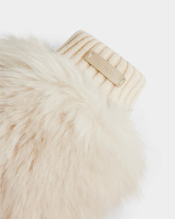 A close-up of the BELLA - 8425006 Vanilla by Rudsak shows a beige, ribbed knit cuff with a Rudsak label attached to cream-colored faux fur—ideal for chic mittens or après-ski accessories—set against a white background.