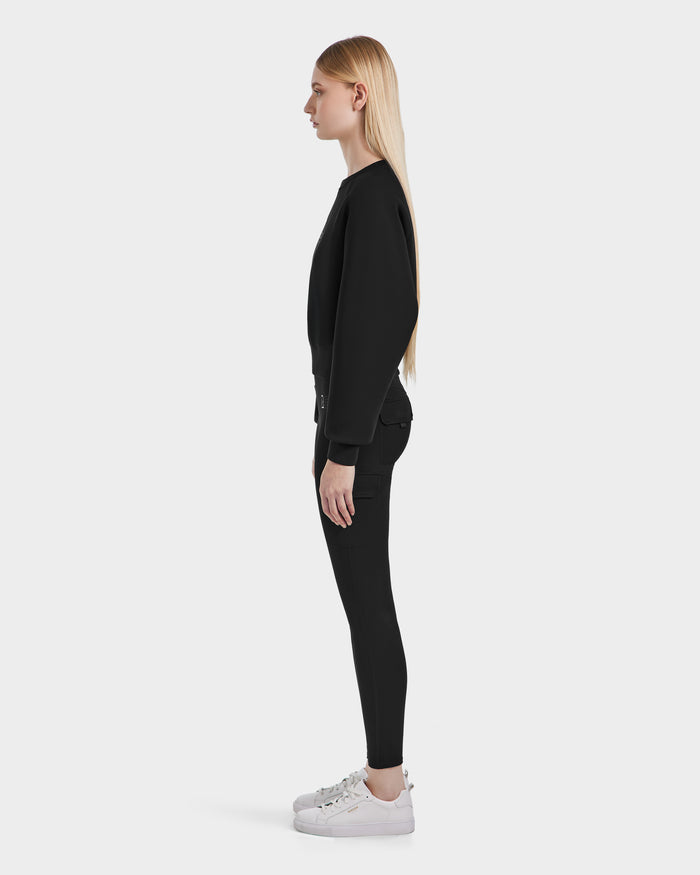 A woman wears the Rudsak BETSY - 8525087 Black premium cotton blend crop sweater.