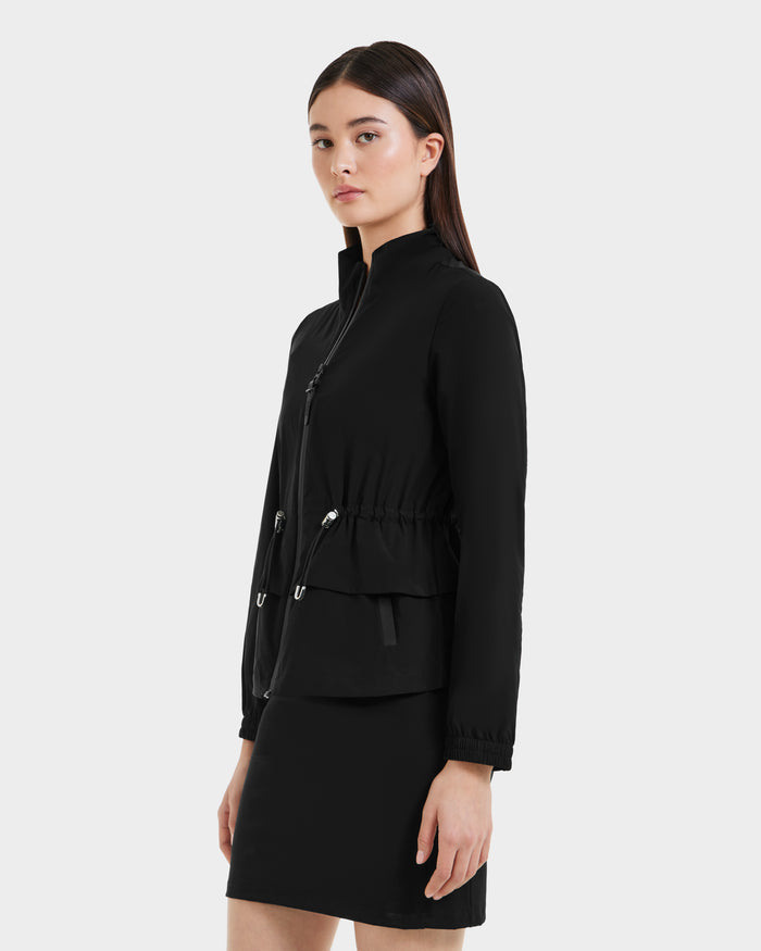 A woman in the Rudsak BONNIE - L125012 Black suit completes her look with a lightweight jacket featuring an adjustable waistcord for a modern touch.