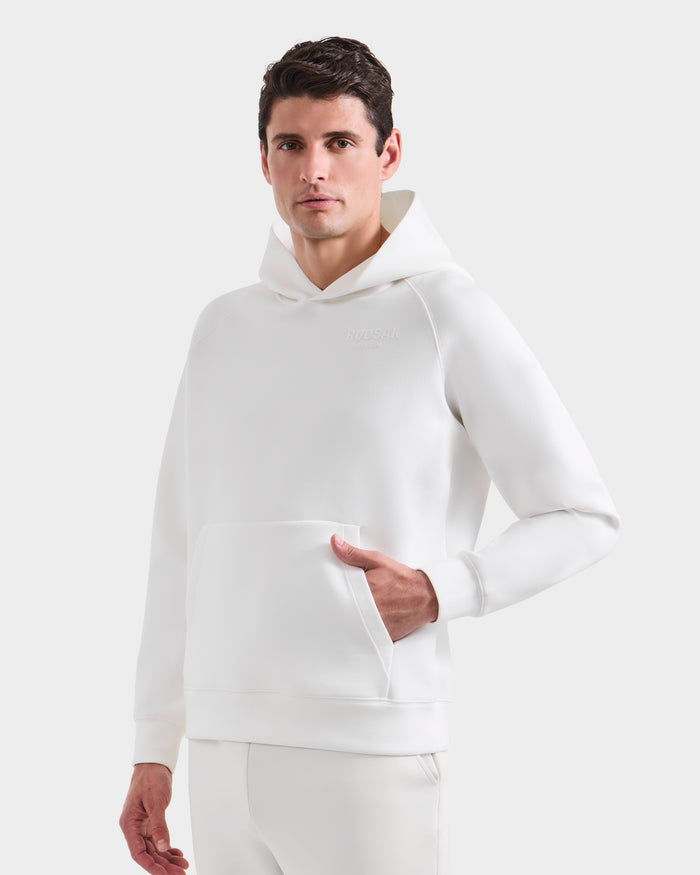 A man models the BRIAR - 9525001 Iceland M unisex hoodie and matching pants by Rudsak in premium cotton blend, standing confidently against a plain white background with one hand in the hoodie pocket for a casual look.