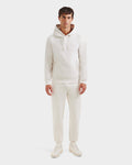 A man faces forward against a plain white background, wearing Rudsak’s BROOKLYN - 6525593 Vanilla hoodie and matching sweatpants, paired with white sneakers.