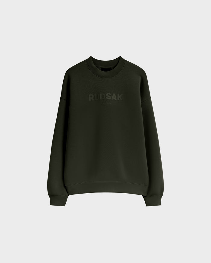 The BRYN - 9524007 Dark Olive M by Rudsak is a dark green cotton crewneck sweatshirt with long sleeves, subtle front branding, an everyday fit, and genderless sizing, displayed on a plain light background.