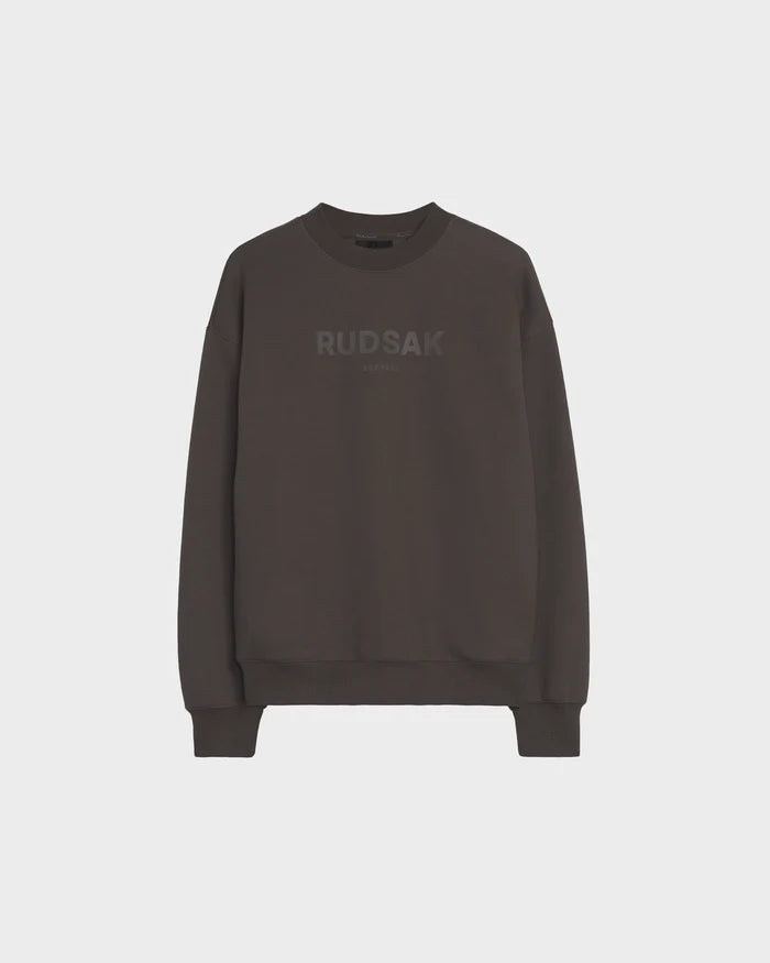 The Rudsak BRYN - 9524007 Grey M is a cotton crewneck sweatshirt with long sleeves, ribbed cuffs and hem, and subtle RUDSAK branding across the chest. Unisex sizing ensures a perfect everyday fit. Laid flat on a plain white background.