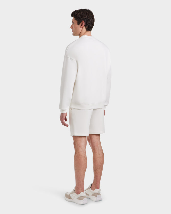 A man faces away, wearing the BRYN - 9524007 Iceland M cotton crewneck sweatshirt and shorts by Rudsak with sneakers, set against a plain white background.