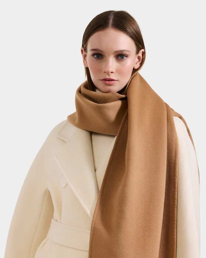 A woman in a cream belted coat and a large camel CALEN - 8425532 scarf by Rudsak stands against a plain light background.