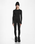 A woman faces forward in an all-black Rudsak CARRIE - 8524619 womens thermal set—beanie, long-sleeve shirt, stretch leggings, and winter boots—against a plain white background.