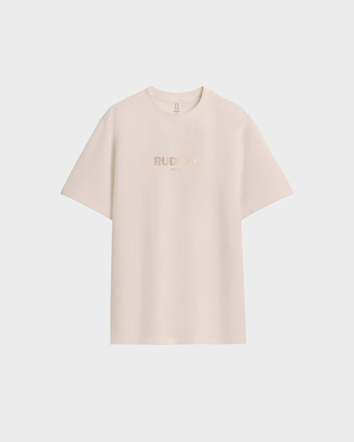 The Rudsak CASEY - 6525037 Vanilla mens T-shirt in off-white features subtle front branding, short sleeves, and a timeless clean design. Displayed on a white background.