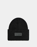 The COLIN - 9424518 Black by Rudsak is a unisex black ribbed knit beanie featuring a wide folded brim and a front rectangular patch with the brand name in raised letters.