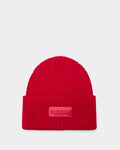 The Rudsak COLIN - 9424518 Flame Red is a bright red unisex ribbed beanie with a folded brim and a rectangular front patch featuring raised RUDSAK lettering. Displayed against a light gray background.
