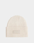 The COLIN - 9424518 Vanilla by Rudsak is a cream ribbed unisex knit beanie with a folded brim and a rectangular patch featuring the Rudsak name in raised letters on the front.