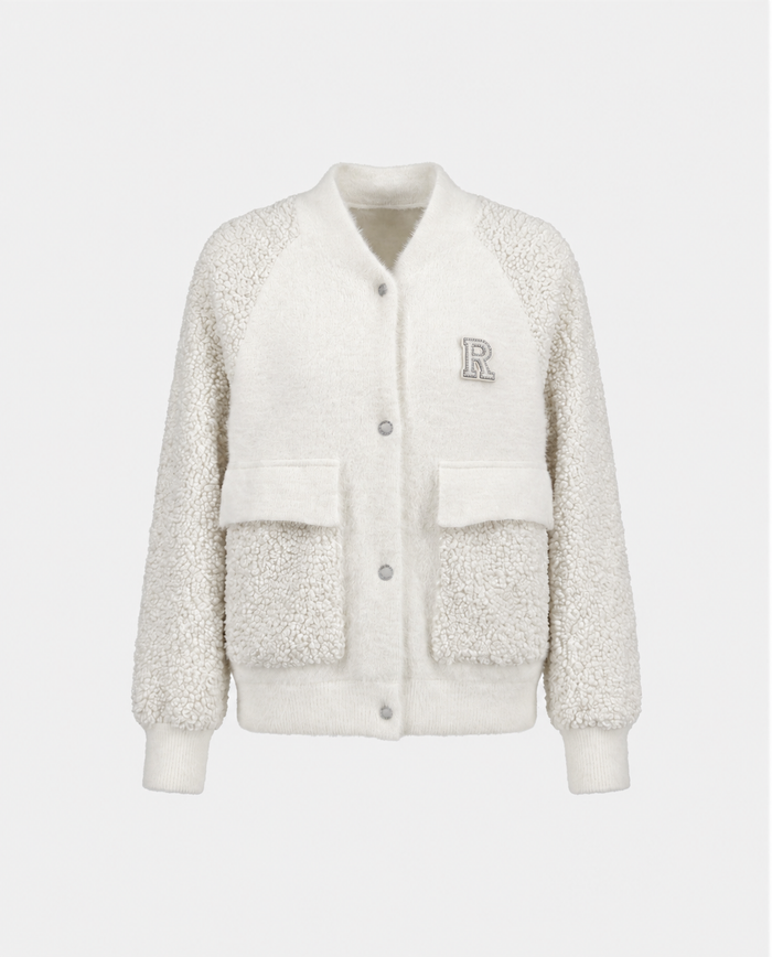 Introducing the DAKOTA - 8526515 Iceland by Rudsak: a cream-colored sherpa varsity jacket featuring ribbed cuffs and hem, front snap buttons, two spacious front pockets, and an embroidered “R” patch on the left chest—perfect for making a statement as a cold-weather layer.