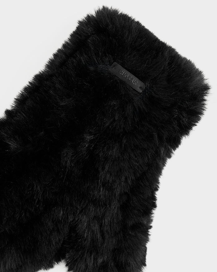 A close-up of ELOISE - 8425559 Black by Rudsak, a soft black faux fur accessory ideal for winter, featuring a small black Rudsak label on a light gray background.