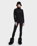 A person wearing the ERIKA - 8525705 Black turtleneck sweater by Rudsak, paired with a black bucket hat, black leggings, and black furry boots stands against a plain white background—a chic addition to any winter wardrobe.