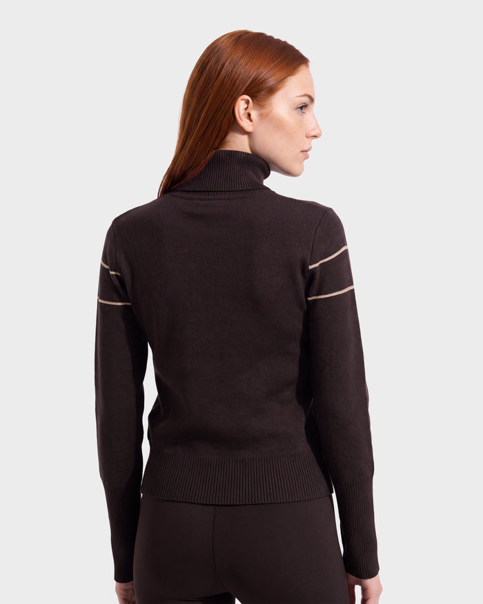A woman with long red hair is wearing the Rudsak ERIKA - 8525705 Espresso sweater, facing away from the camera against a plain light background, showcasing an elegant choice for any winter wardrobe.