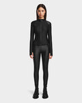 A woman faces forward, wearing the Rudsak EVA - 8524514 Black fitted zip-up top with waterproof zipper and matching leggings, paired with black lace-up boots, against a plain white background.