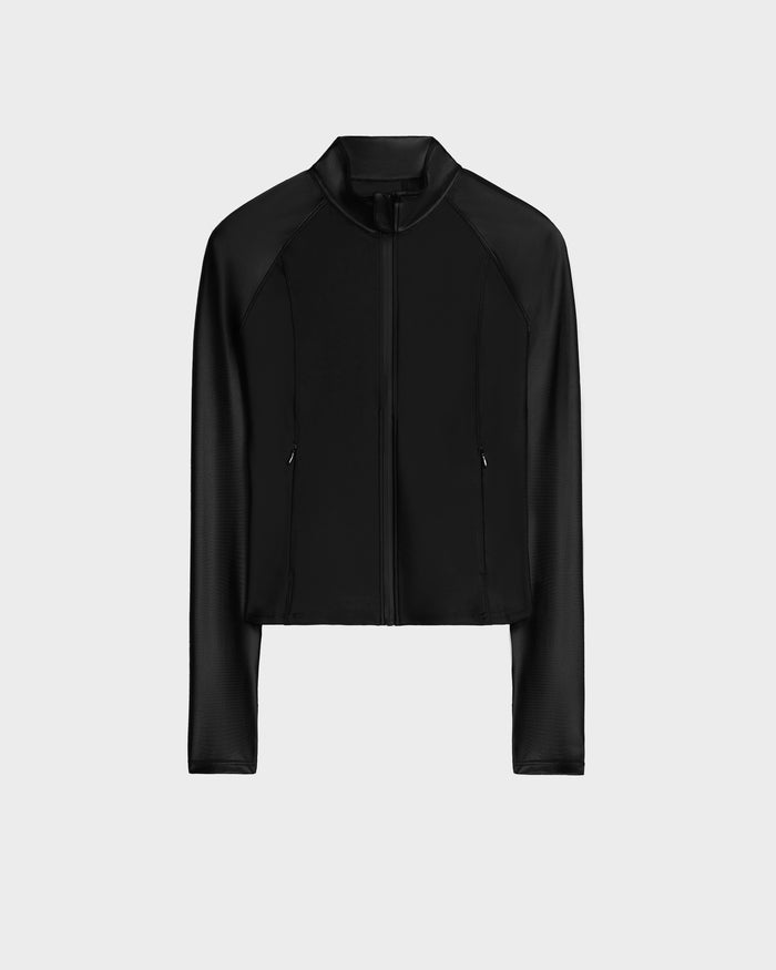 The Rudsak EVA - 8524514 Black is a women’s black, long-sleeve cropped zip-up top in shiny stretch fabric with a subtle collar and waterproof zipper, shown on a plain light gray background.