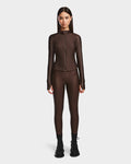 A woman faces forward in the Rudsak EVA - 8524514 Espresso fitted long-sleeve zip-up top with waterproof zipper, matching brown leggings, and black lace-up boots, set against a plain white background.