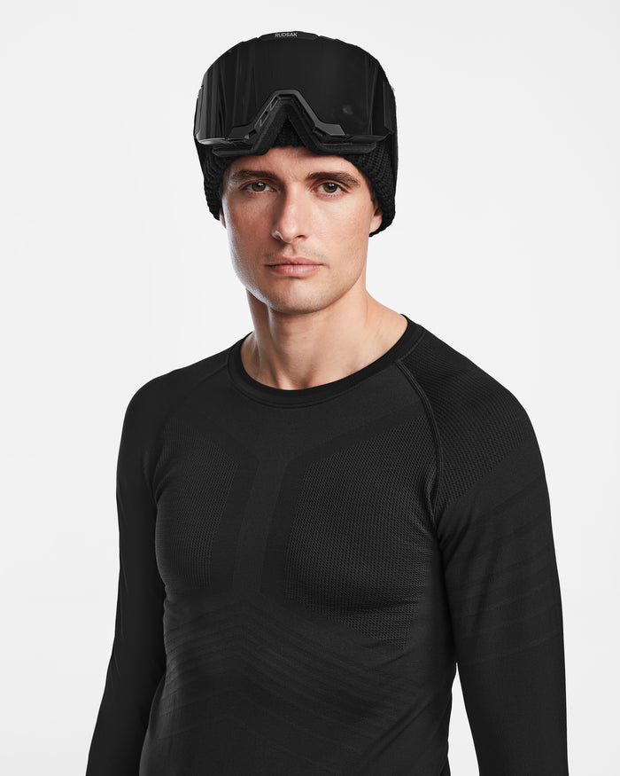 A man in Rudsaks FRANC - 6524541 Black hat and goggles, dressed in a base layer set ideal for ski underlayer warmth.