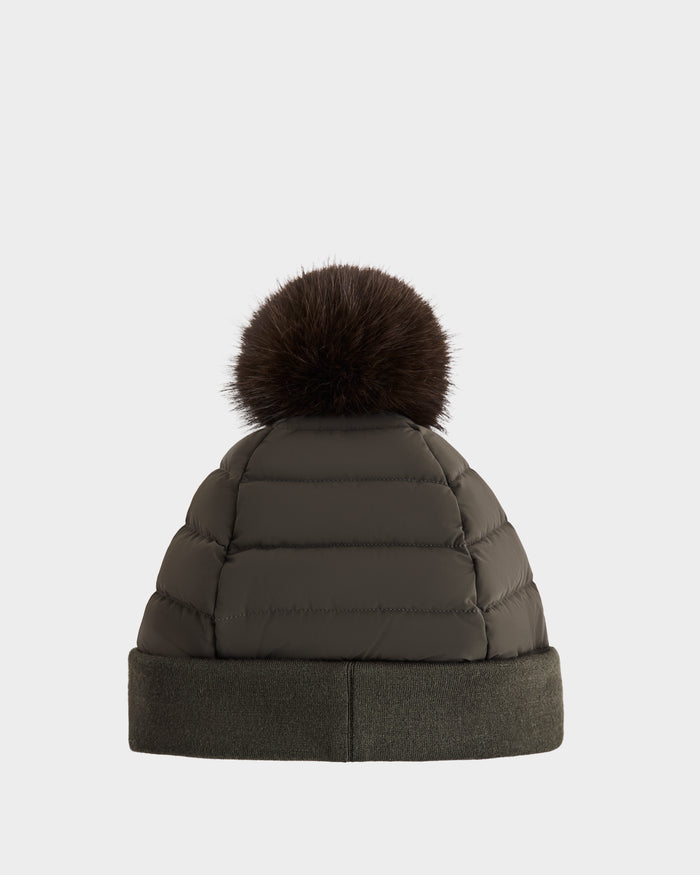 The Rudsak GALA - 8424514 Dark Olive is a women’s quilted down puffer hat featuring a wide cuff and a large removable faux fur pom pom, shown against a plain white background.