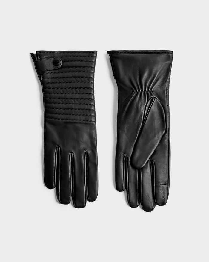The Rudsak GEMMA - 8425008 Black gloves are shown flat on a light surface—one displays the back with stitched detail and snap closure, the other reveals the palm side with gathered wrist—perfect for winter.