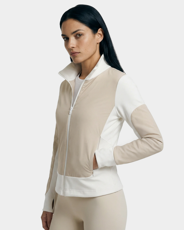 A woman with long dark hair models the Rudsak GRANADA - 8126023 Vanilla sweater jacket and matching leggings, standing with one hand in her pocket against a plain light background.
