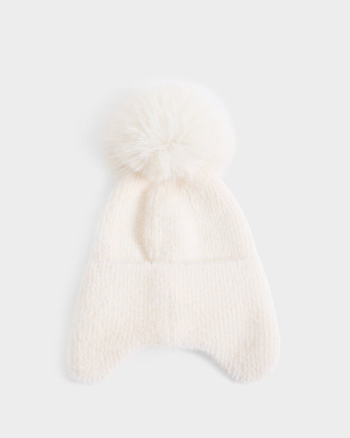 The Rudsak ICE - 8426519 Vanilla is a white knit winter hat featuring ear flaps and a large, fluffy pom-pom on top, shown against a plain white background.