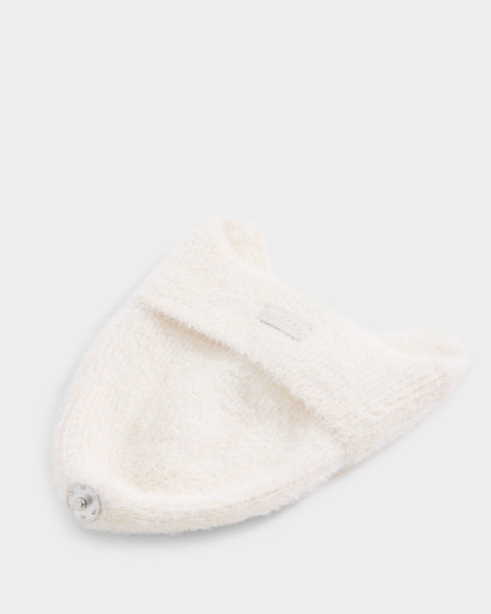 The Rudsak ICE - 8426519 Vanilla is a soft, white, textured knit hat featuring two small ear-like points and a metallic button accent, displayed on a light background.