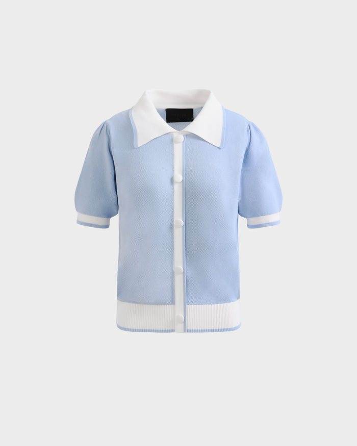 The IRIS - 8526012 Powder Blue short-sleeve sweater by Rudsak features a light blue knit, white ribbed cuffs and hem, contrast pointed collar, white buttons down the front, and is shown on a plain light gray background.