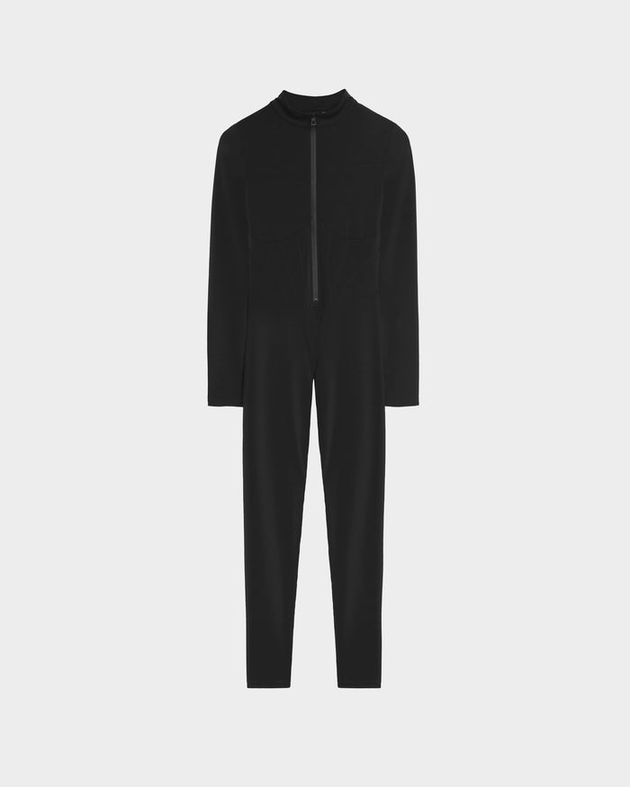 The Rudsak IVY - 8524599 Black is a womens black, long-sleeve, full-length stretch bodysuit with a front zipper and chest pockets, shown on a plain white background.
