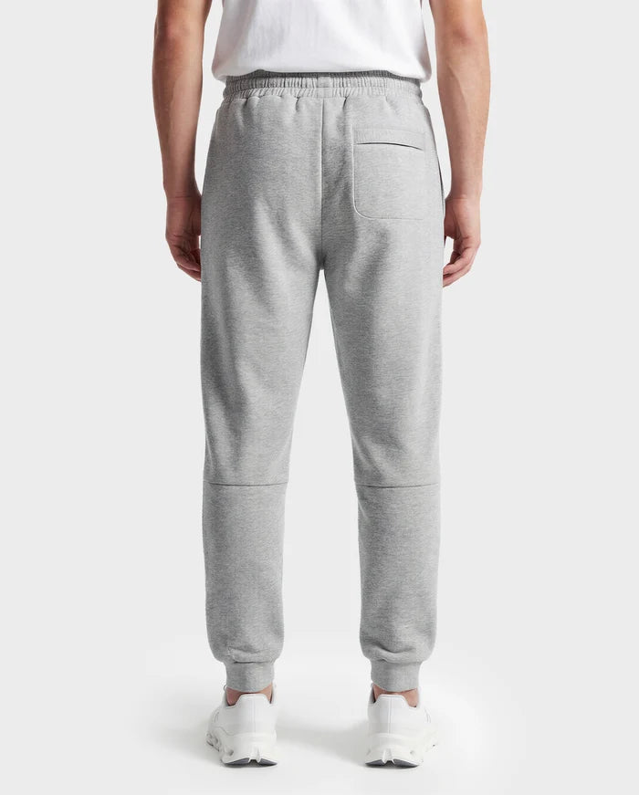A person is seen from behind wearing Rudsak's JOSS - 9524009 Heather Grey M unisex jogger sweatpants with an elastic waistband and a single back pocket, styled with a white t-shirt and white sneakers.