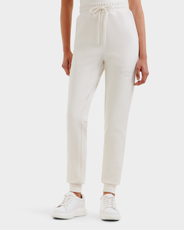 A person models the Rudsak JOSS - 9524009 Vanilla W joggers, featuring an elastic waistband and drawstring, paired with white sneakers. Only their lower half is shown against a plain background to highlight these off-white joggers.