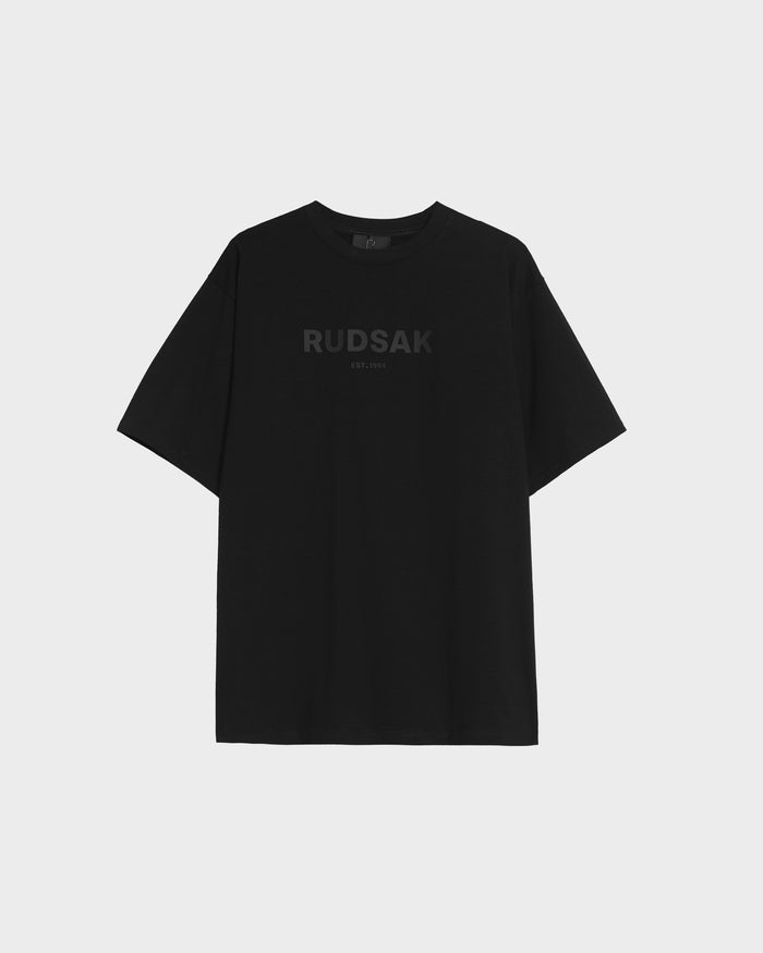 The KARTER - 9524008 Black W by Rudsak is a unisex, oversized T-shirt made from premium cotton, featuring RUDSAK EST. 1994 in dark print on the chest and shown on a light gray backdrop.