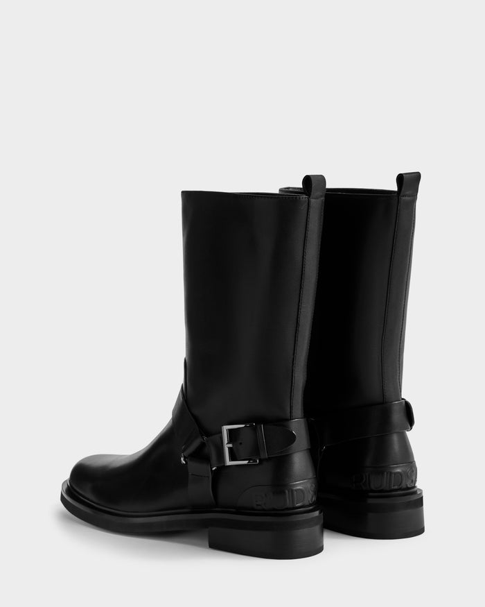 KIRRA - 8225558 Black by Rudsak: black leather moto boots with mid-calf height, low heels, side metal buckles, and back pull tab, displayed on a plain white background.
