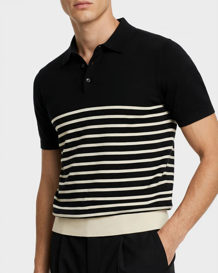 A man wears the Rudsak KRIS - 6526005 Black fine-gauge knit polo with contrast stripes and a white waistband, paired with black pants. His face is partially out of frame.