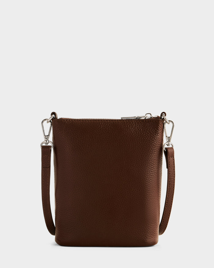 The Rudsak LILA - L325513 Mocha is a small, brown pebbled leather women’s crossbody bag with a textured surface, detachable shoulder strap, and silver hardware, shown against a plain white background.