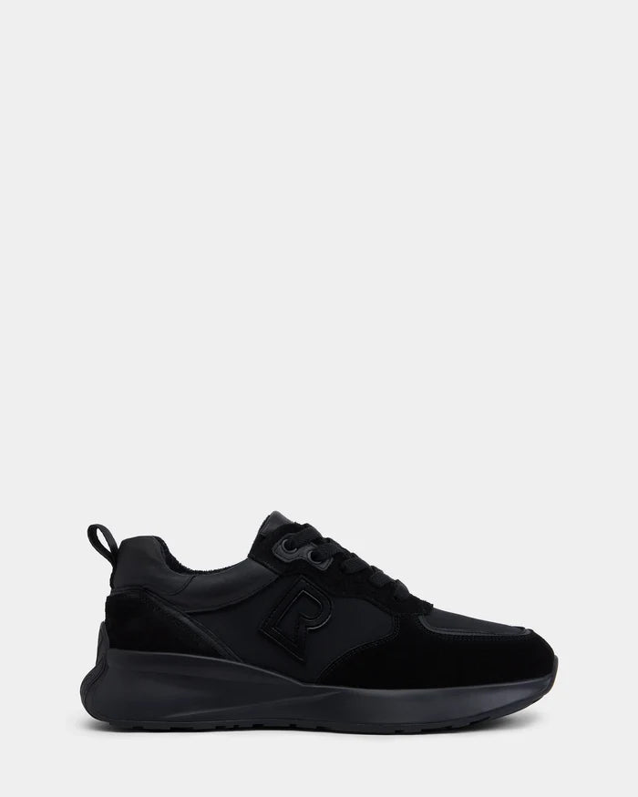 The Rudsak LIONEL - 6225001 Black is a men’s lace-up sneaker featuring black suede and smooth overlays, thick sole, black laces, and an embossed R logo on the side, offering a modern look against a light grey background.