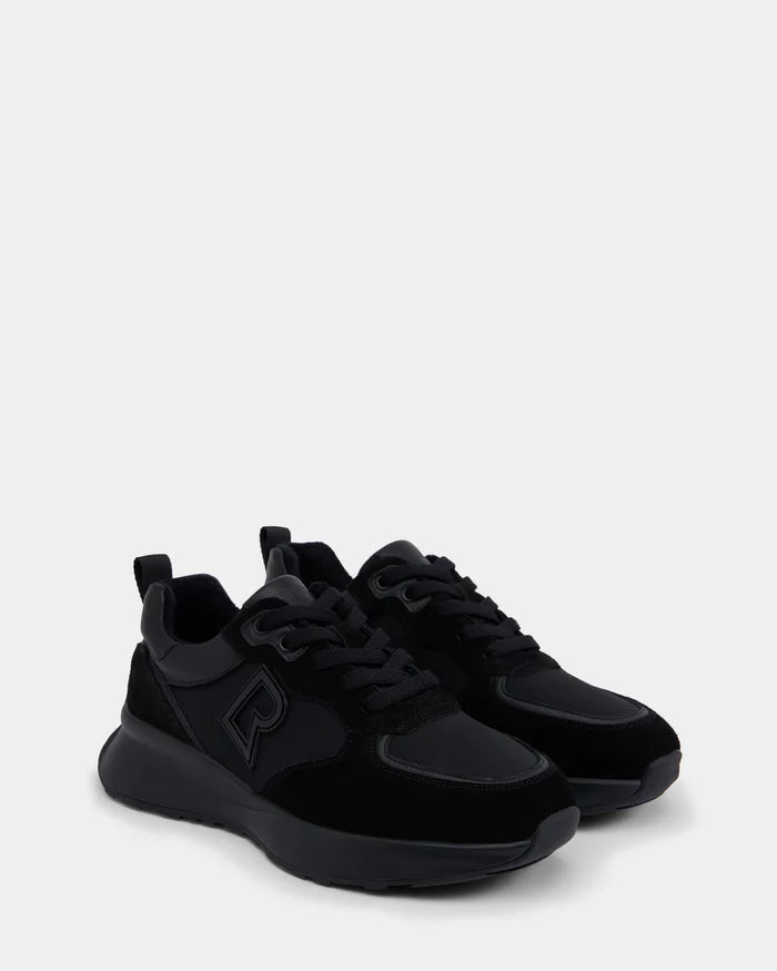 The LIONEL - 6225001 Black men’s sneakers by Rudsak feature thick, durable soles and a raised R logo. Shown side by side on a light gray background, these modern black lace-up shoes combine style and comfort.