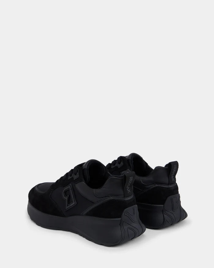 The Rudsak LIONEL - 6225001 black men’s sneakers feature thick soles and “RR” logos on the sides and heel tabs. Their modern design stands out as they are angled back and left against a plain light gray background.