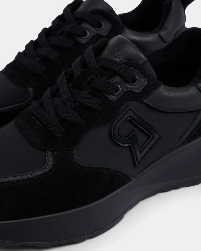 Close-up of Rudsaks LIONEL - 6225001 Black mens sneaker, featuring a thick sole, raised embossed logo, and a modern mix of suede and smooth materials—combining style and durability for everyday wear.