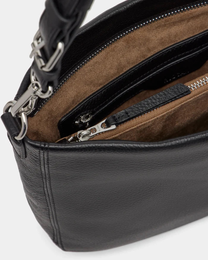 Close-up of the Rudsak LUCYLE - 8325012 Black women’s leather hobo bag with silver hardware, brown suede-like interior, zippered pocket, and a leather strap with chain links.