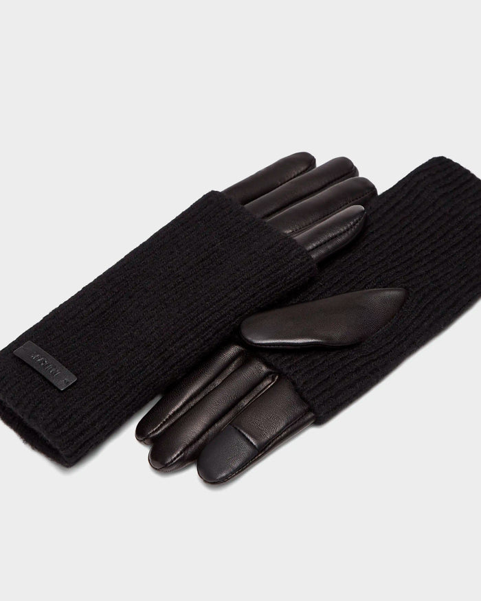 The Rudsak MARINE - 8424516 Black/Black women’s gloves combine ribbed knit backs with smooth leather palms and fingers, offering chic fall style, shown on a light gray background.