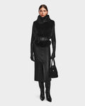A woman styles the Rudsak MAULIN - 8524611 Black faux fur vest with sleek vegan leather pants for a modern, fashionable look.