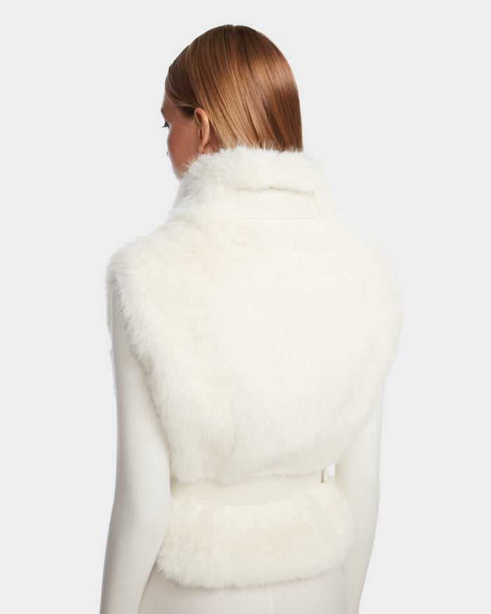 A person with straight, light brown hair is shown from behind wearing the Rudsak MAULIN - 8524611 Iceland white sleeveless faux fur vest over a fitted, long-sleeve mock-neck pullover against a plain light background.