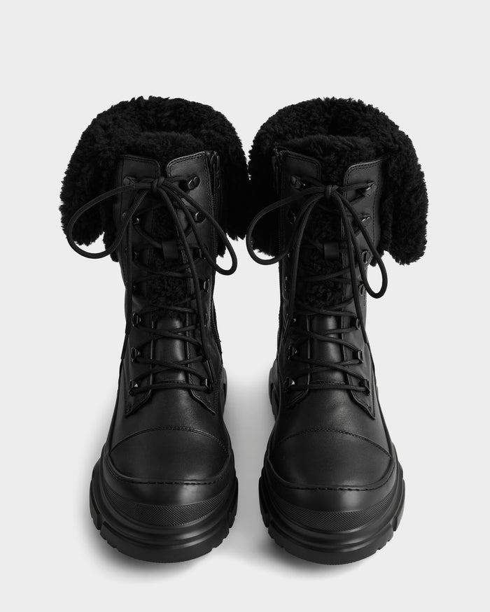 The MODENA - 8225024 Black boots by Rudsak are black lace-up winter boots with thick soles and folded-down, fluffy faux shearling linings, displayed from above on a plain white background.